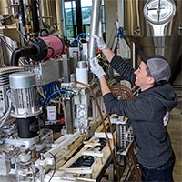 Lindsey adding ends to the lid stack on the canning line