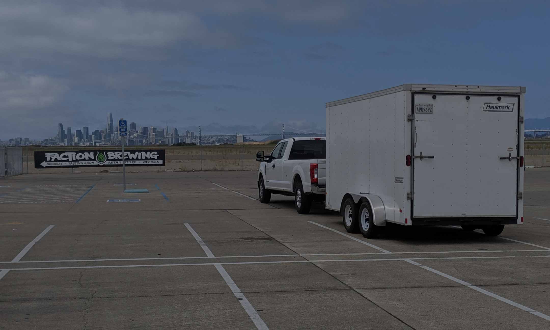 The Can Van truck and trailer parked in an empty lot at Faction Brewing